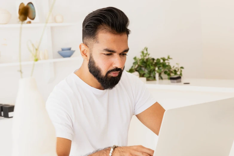 a man with a beard is using a laptop