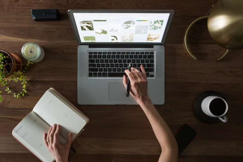 a person sitting at a table with a book and computer