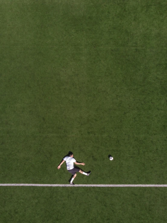 a man kicking around a soccer ball on top of a field