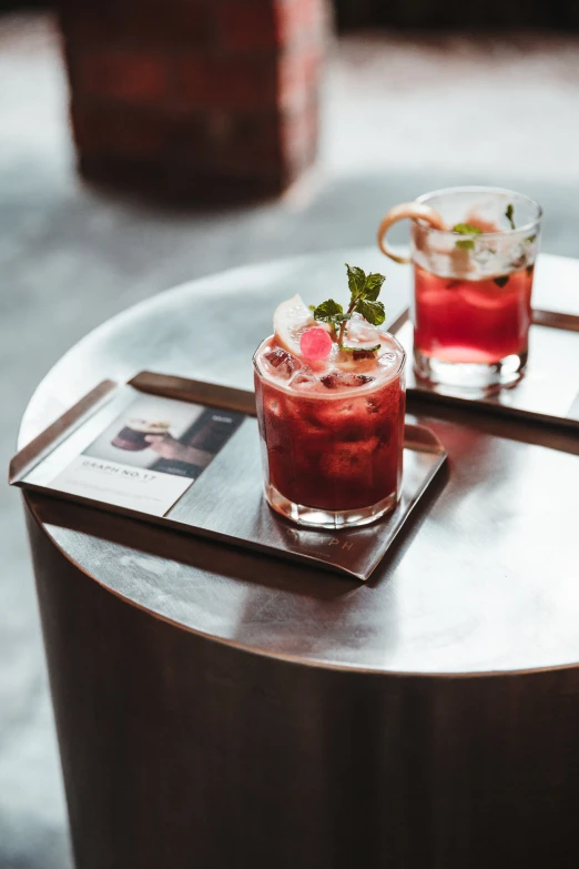 two drinks sitting on top of a silver table