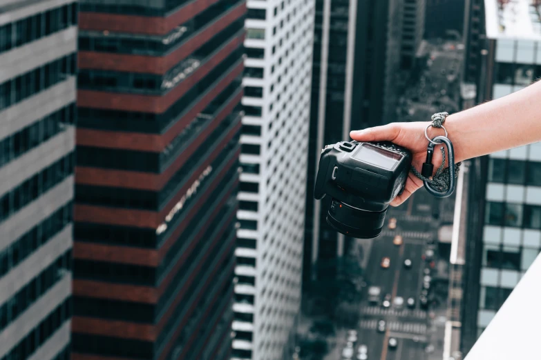 hand holding camera in front of cityscape view