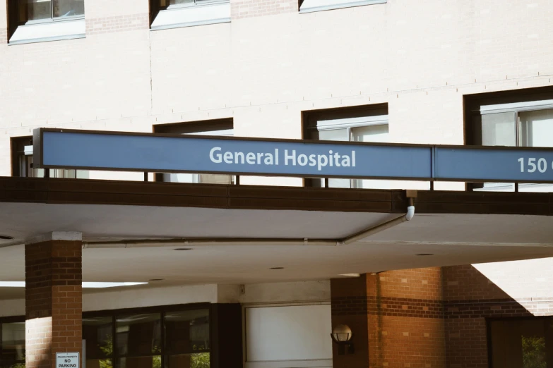 a hospital sign with a brick building in the background