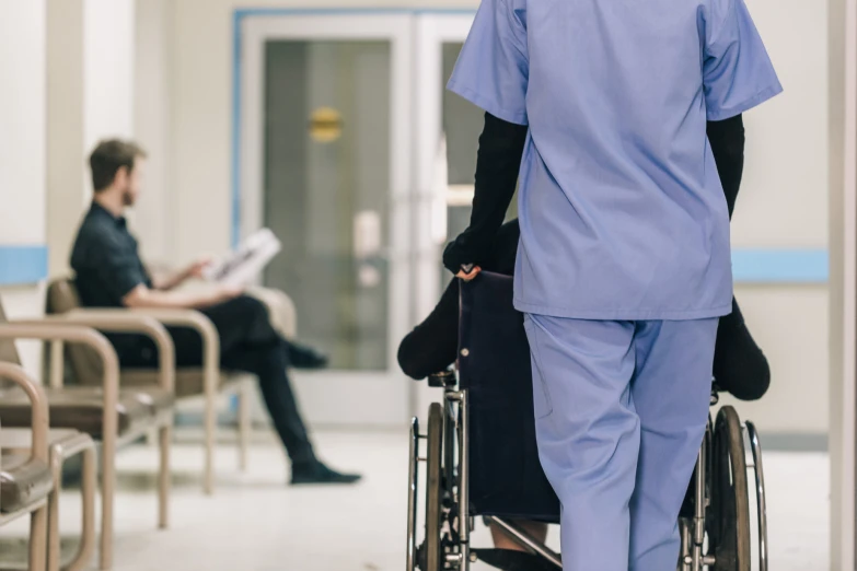 a man in blue scrubs riding a wheelchair