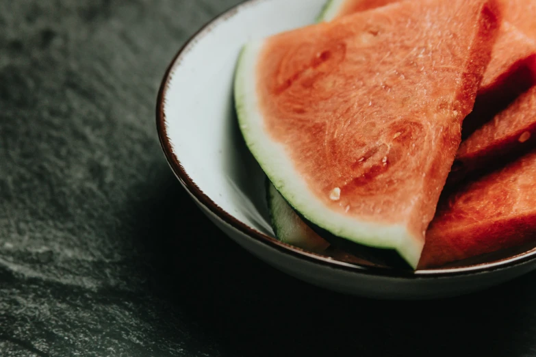 two pieces of watermelon sit in a bowl