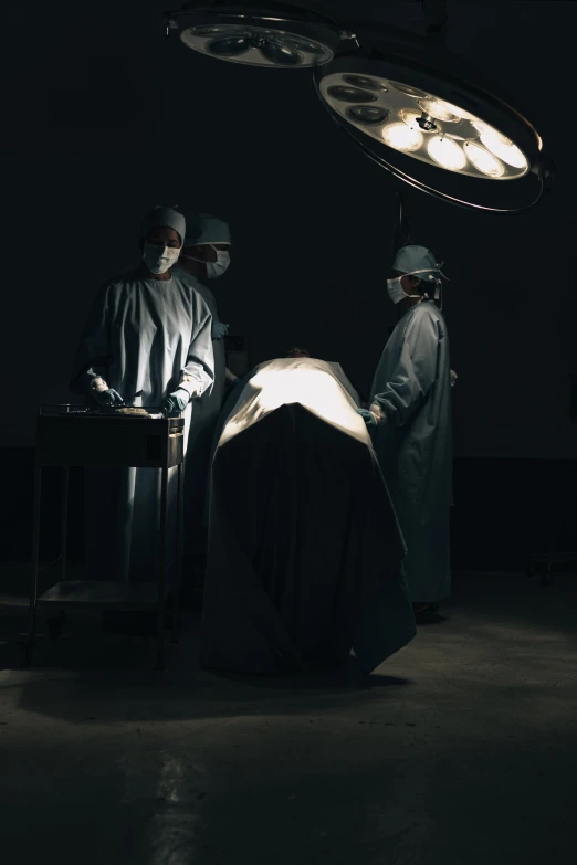 a surgeons doing  in the dark with an operation light overhead