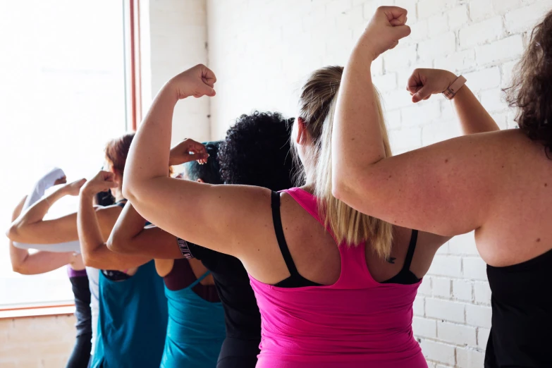 people standing in a room raising their arms