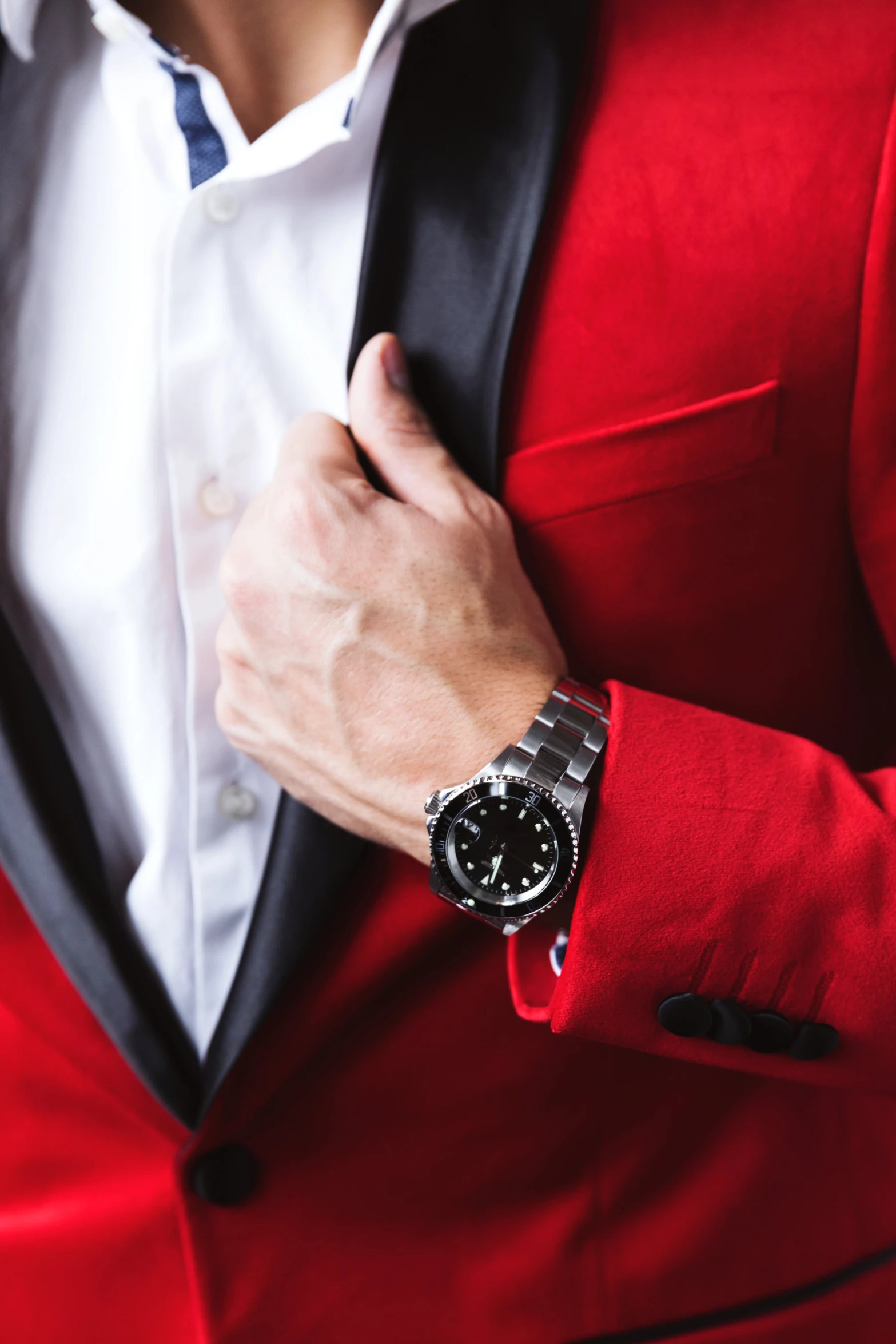 a person in a red jacket adjusting the collar of their watch