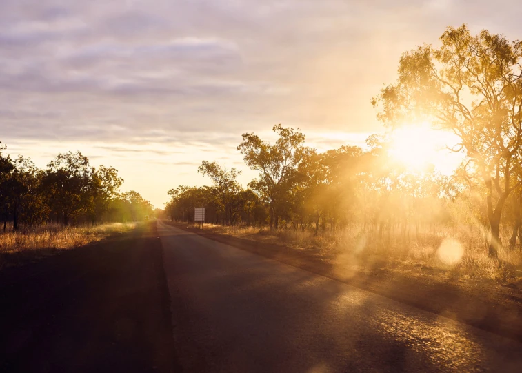 a long road with the sun coming down