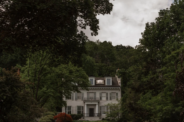 a white house surrounded by trees on the other side