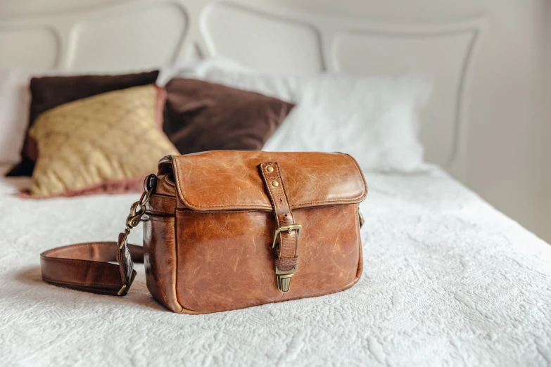 there is a large leather handbag on the bed