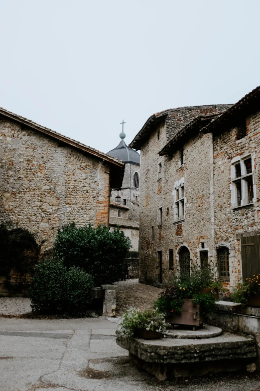 the courtyard of an old stone building with plants and steps