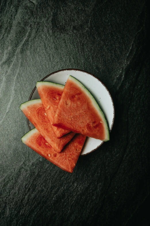 slices of watermelon on a white and black plate