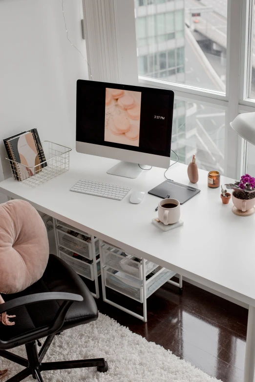 a chair is in front of a large window with a computer on top