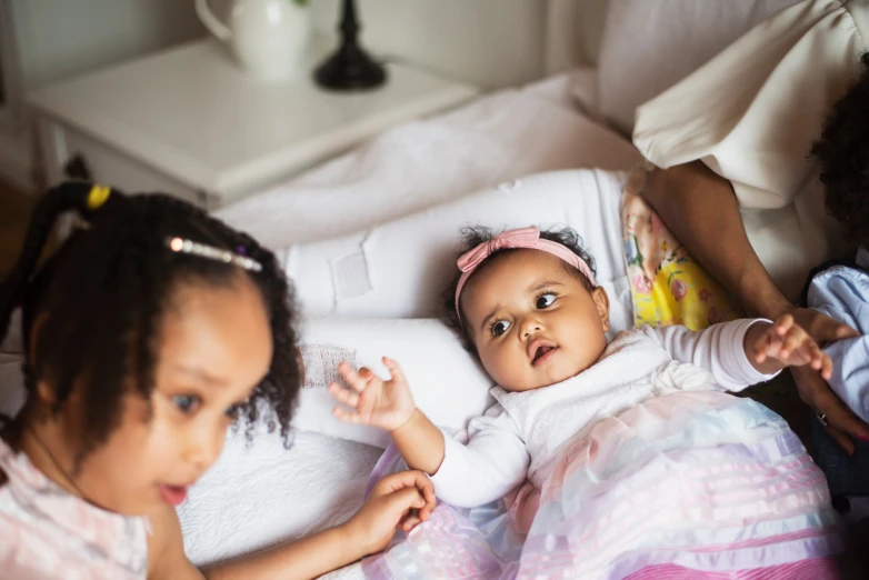 two young children are laying down together on a bed