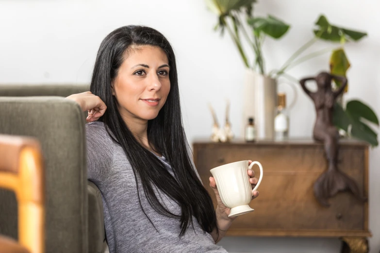 a beautiful woman holding a white coffee mug