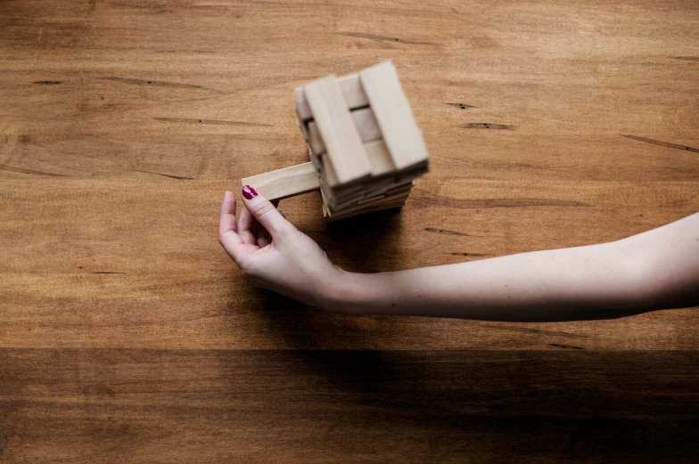 a hand with a nail painted manicure holding an object out