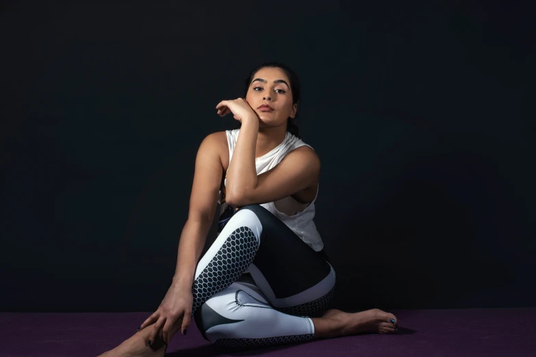 a beautiful young woman sitting on the ground