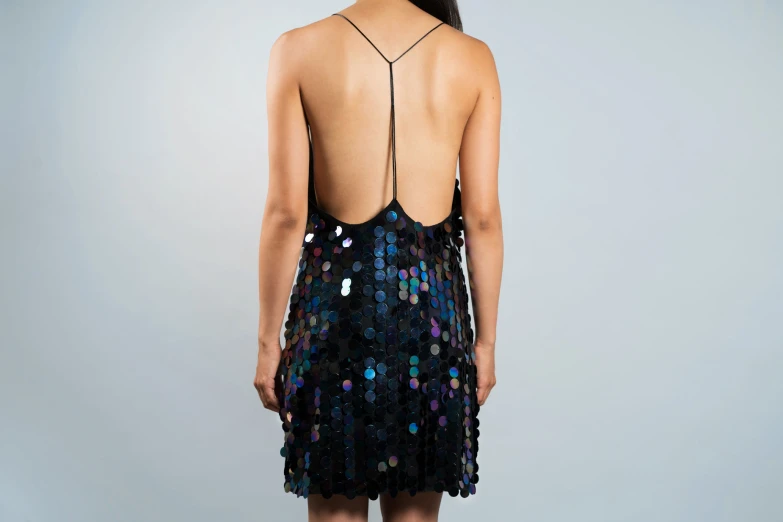 a model in a dress that has sequins on the back