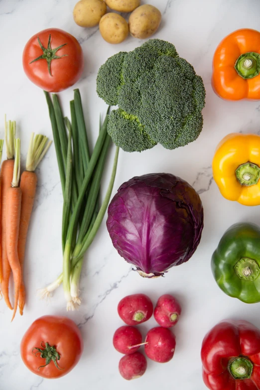 many different vegetables sitting on a white counter