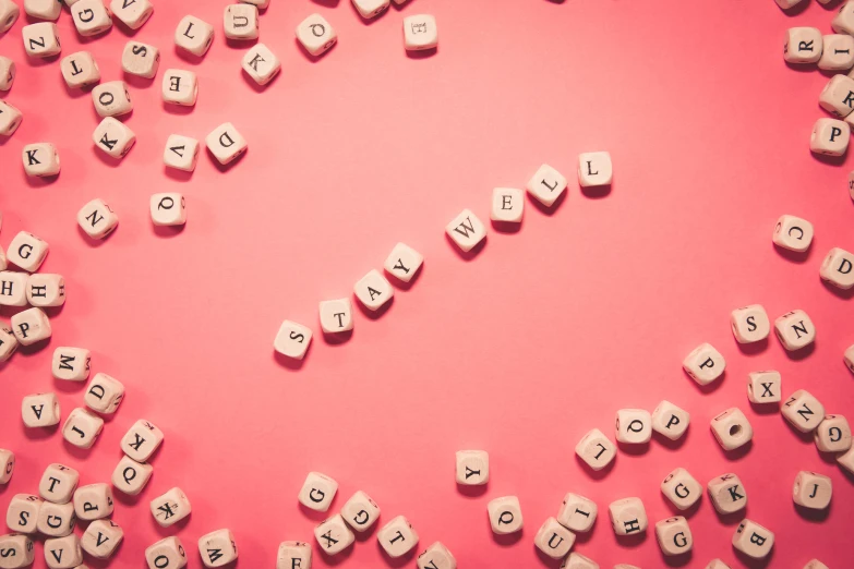 a pink background with several white letter cubes