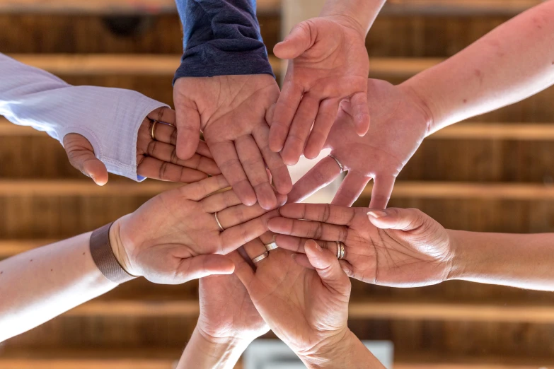 several hands are holding each other in the center