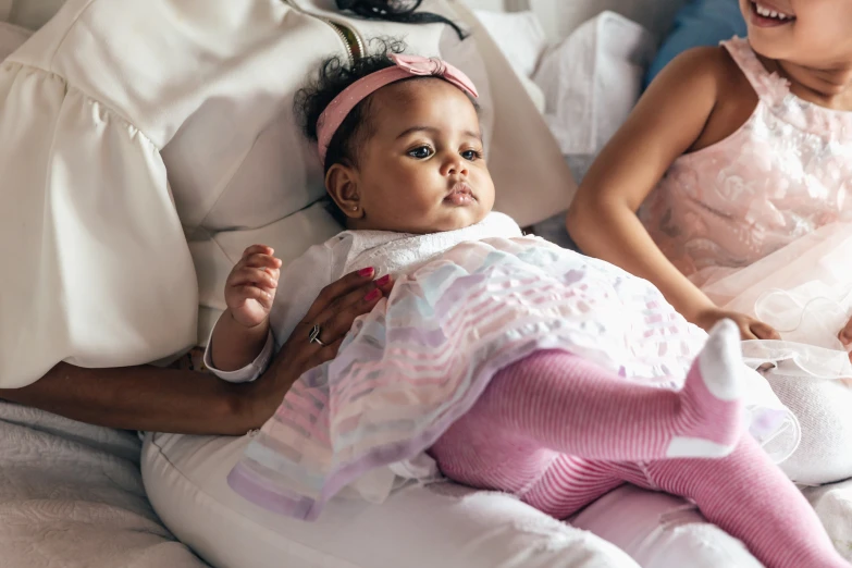 there is a baby laying on a bed next to two women