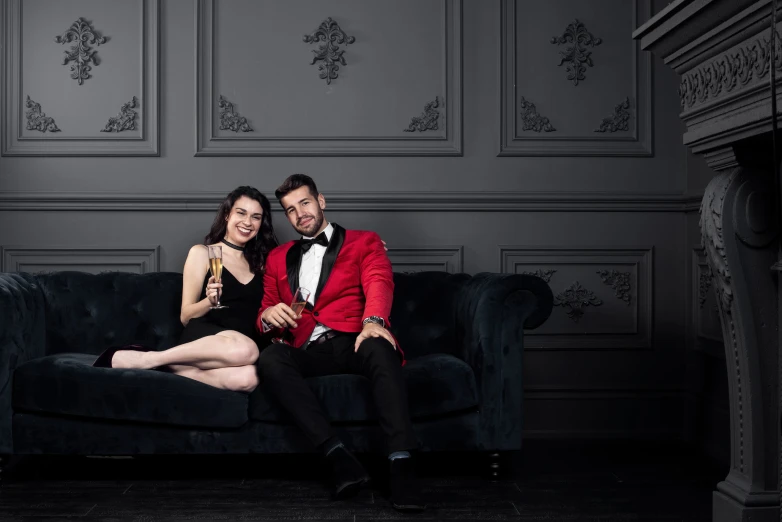 a couple in evening wear posing for a po on the couch