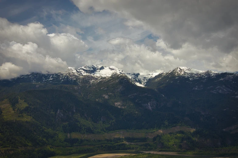 some very nice mountains under some clouds and snow