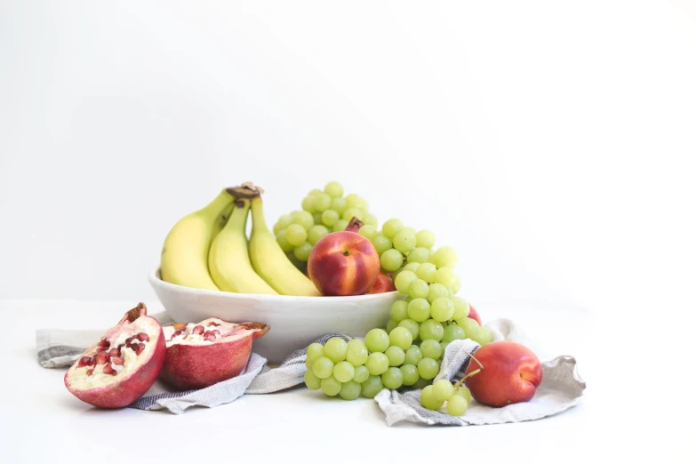 a bowl of fruit with a half of a banana and some other fruit next to it