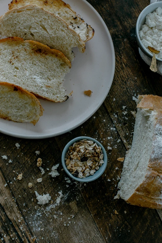 a plate with bread, bowl and spoons on it