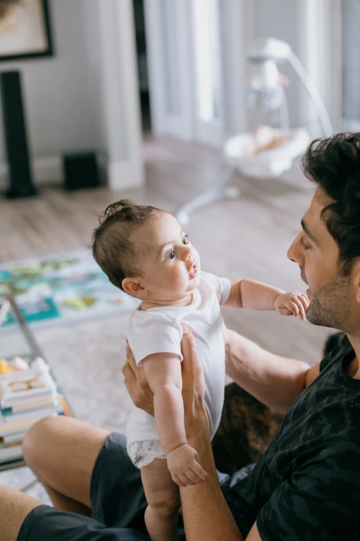 a man holding a baby up to its face