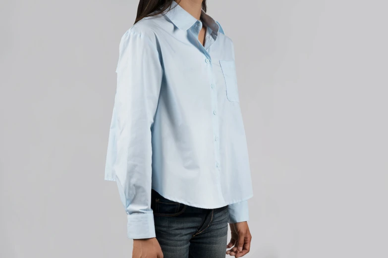 a woman is wearing a light blue shirt and jeans