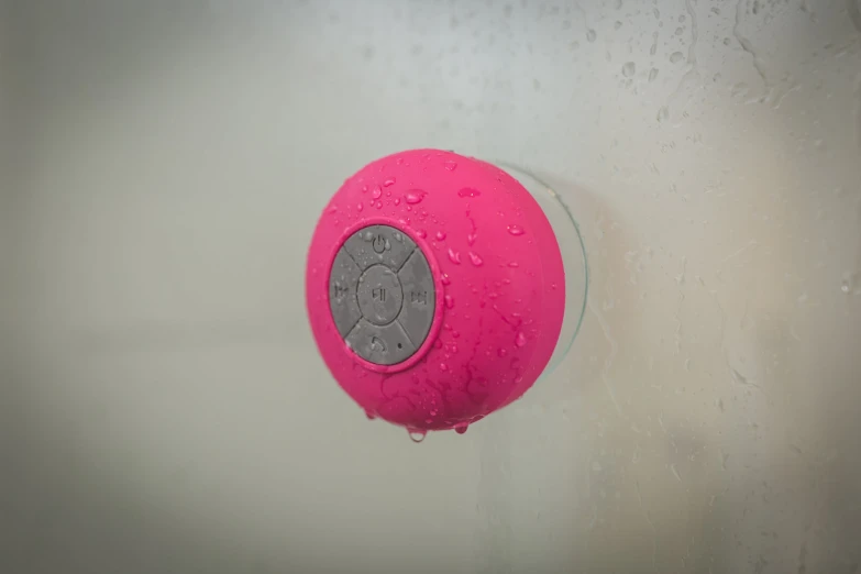 water droplets on the glass outside of a pink shower head