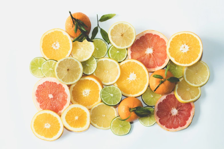 a pile of sliced citrus and limes on a white surface