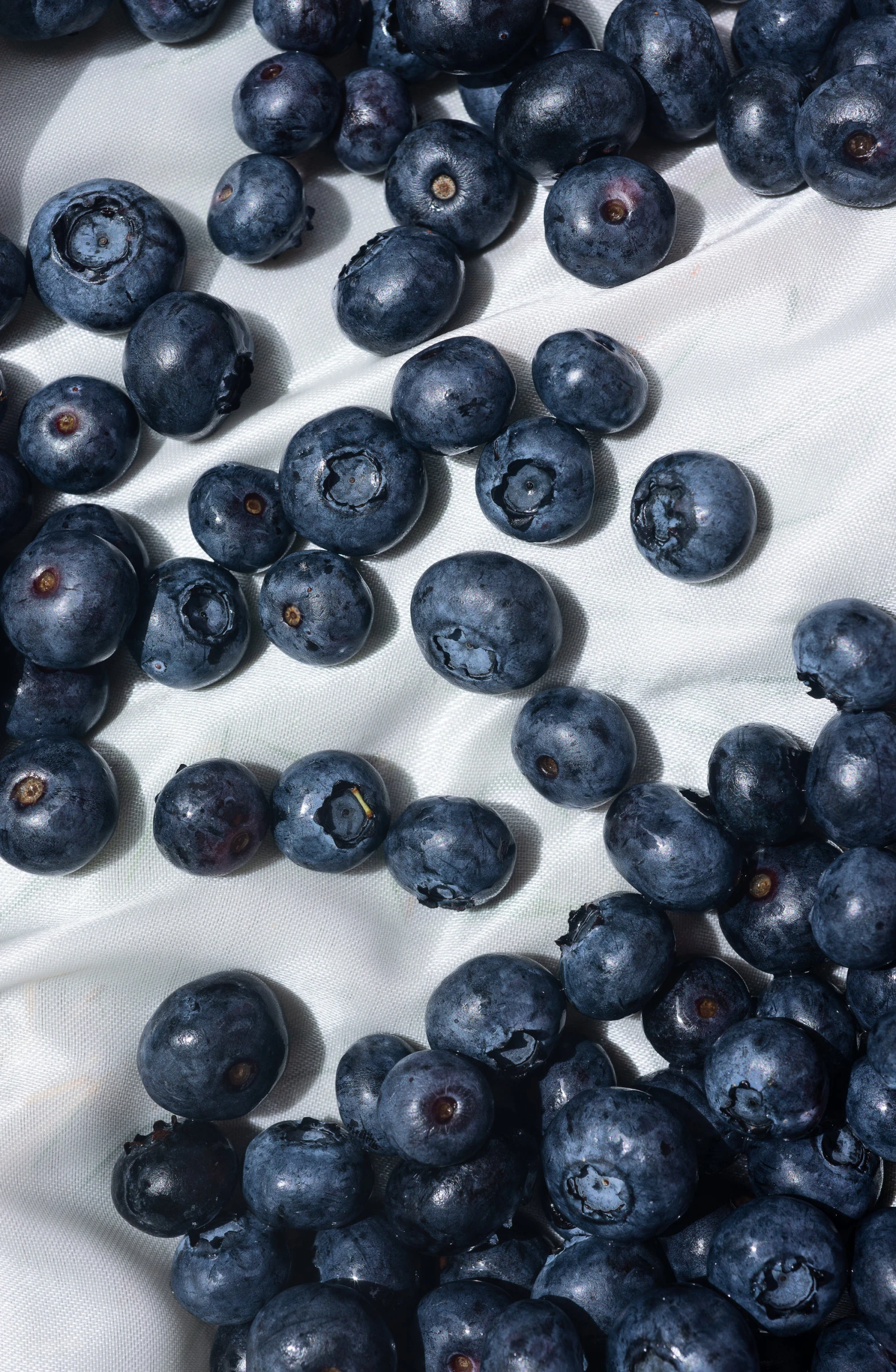 blueberries are on the table next to the cloth