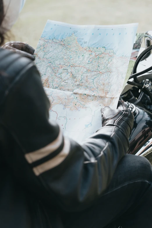 a person looking at an atlas map with a cat sitting on the bike