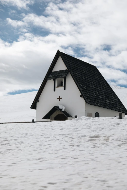 a white house with a black roof on a hill