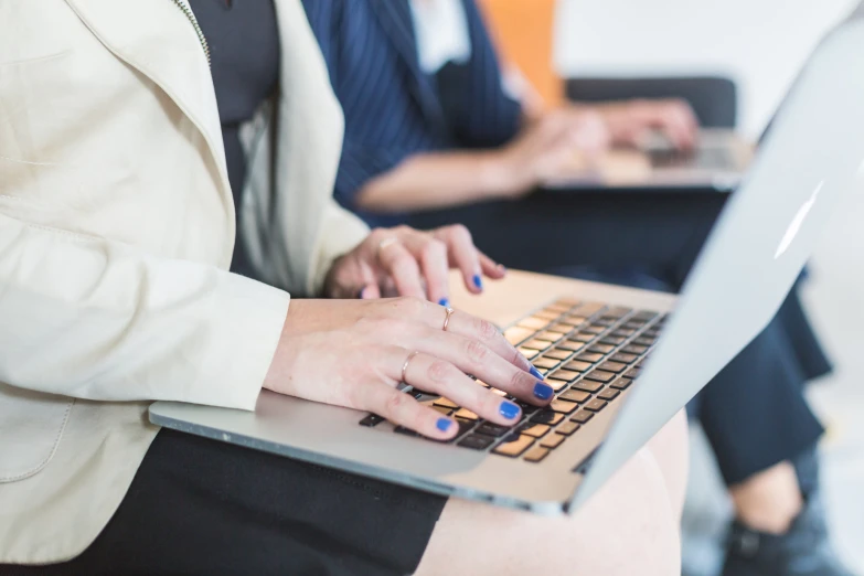 woman typing on her laptop with both hands