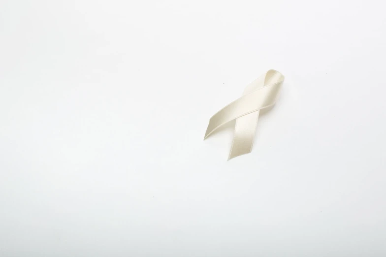a single white ribbon that is sticking out of a table