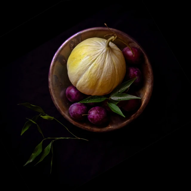 a yellow squash and red gs in a wooden bowl