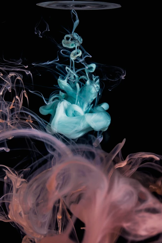 a pink and green substance floats in water