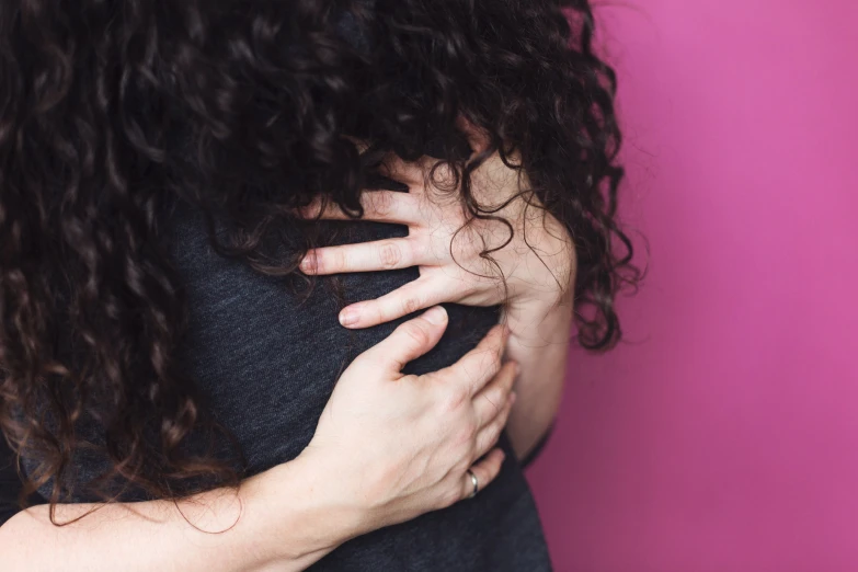 a close up of a person hugging her back