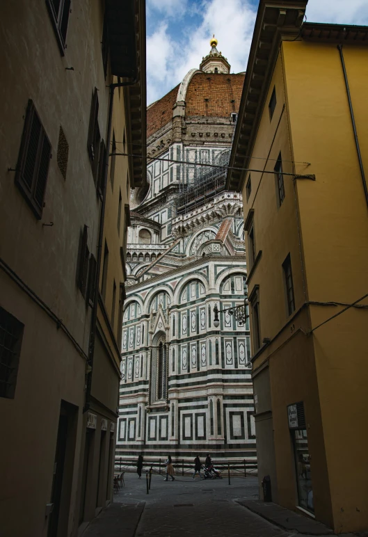 a narrow walkway with an ornate building on top