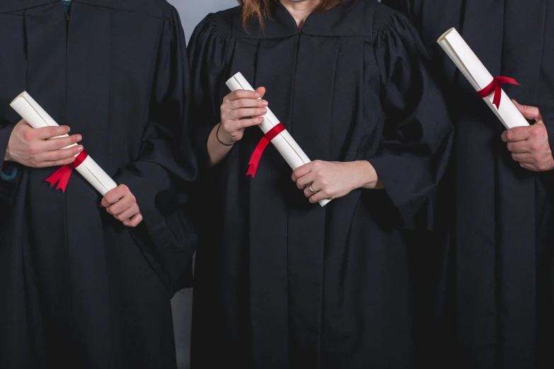 five people in graduation gowns posing for a picture