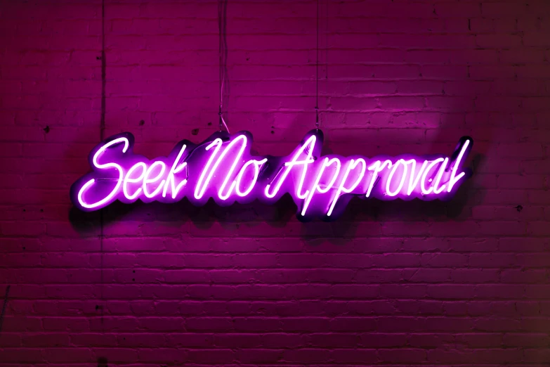 a neon sign reading see no attachment on a brick wall