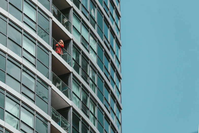 some people hanging out from the windows of an apartment building