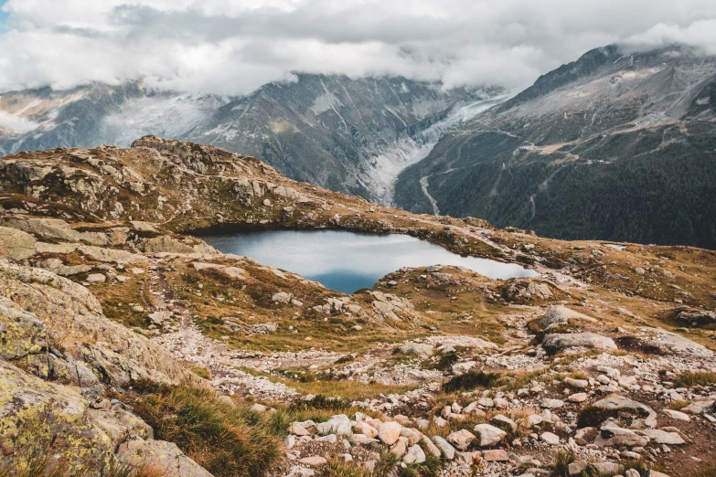 the view of mountain peaks from above, with a little pond in the middle