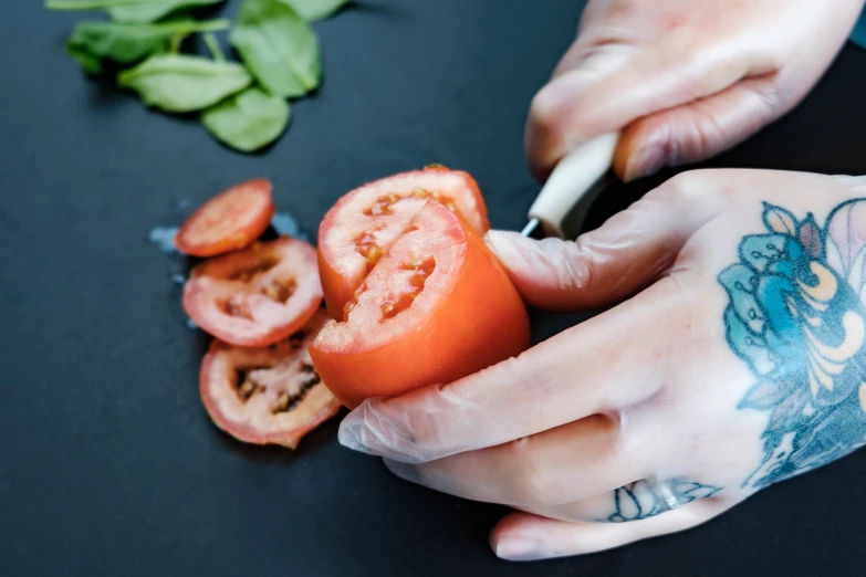 a person is  up a tomato on the table