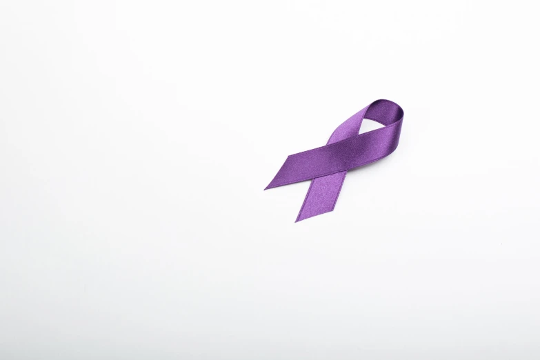 a purple ribbon is shown laying on top of a table