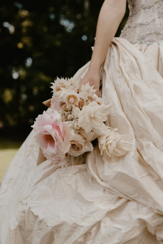 a bride is dressed in a wedding gown with flowers